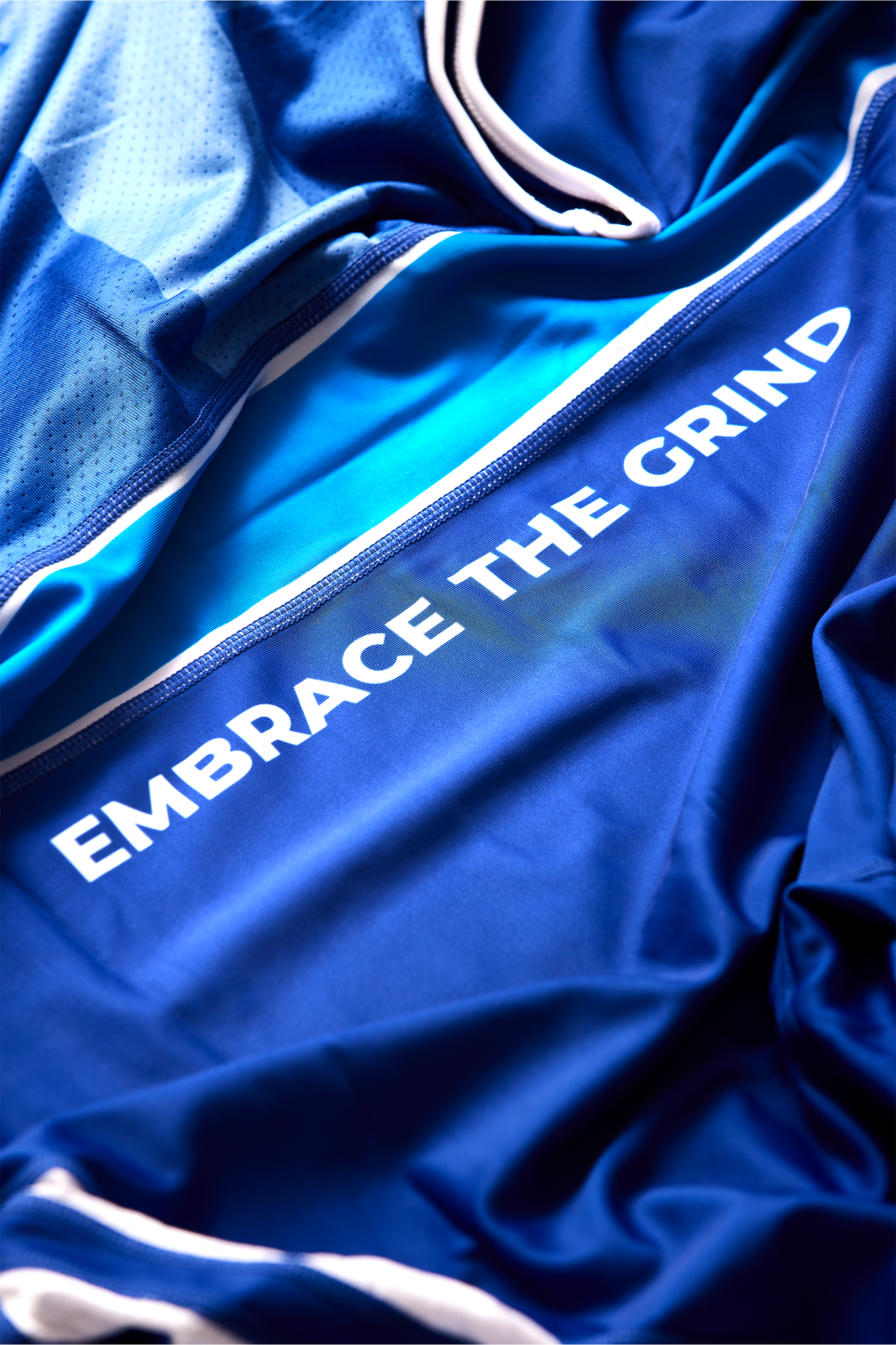 Tekst Embrace the Grind på blå bryderdragt til brydning for Danmark. Køb brydetrikot