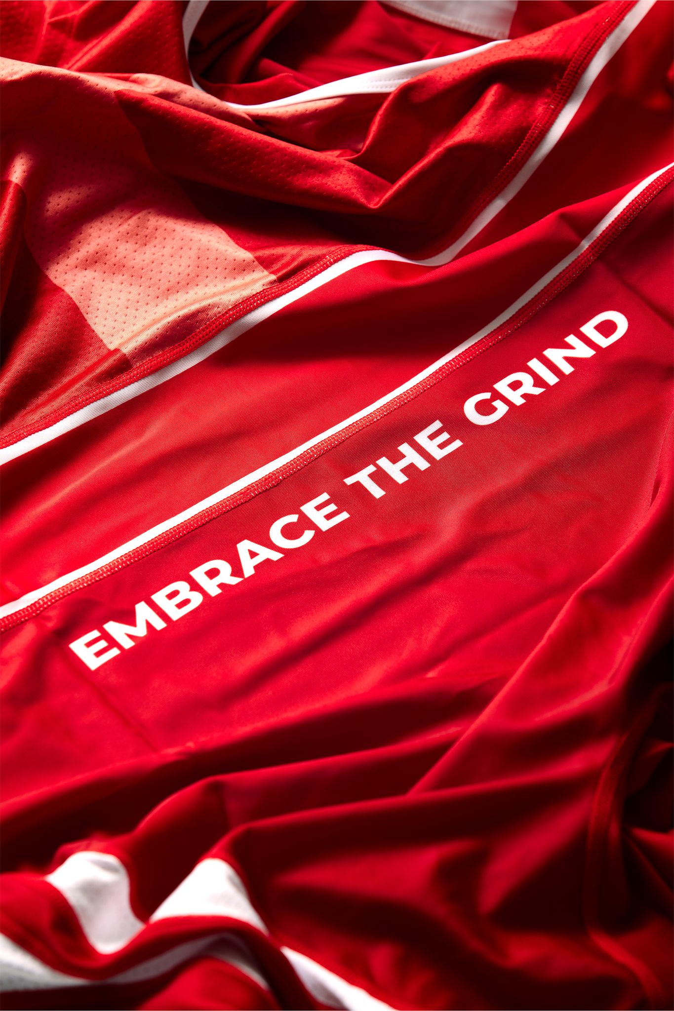 Tekst Embrace the Grind på rød bryderdragt til brydning for Danmark. Køb brydetrikot